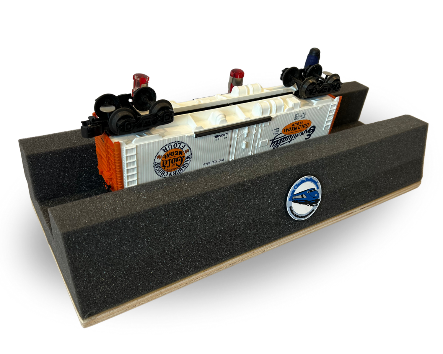A gray polyurethane handy holder with stabilizing woodbase, featuring three convenient handy tool holes, and displaying toy trains on top.