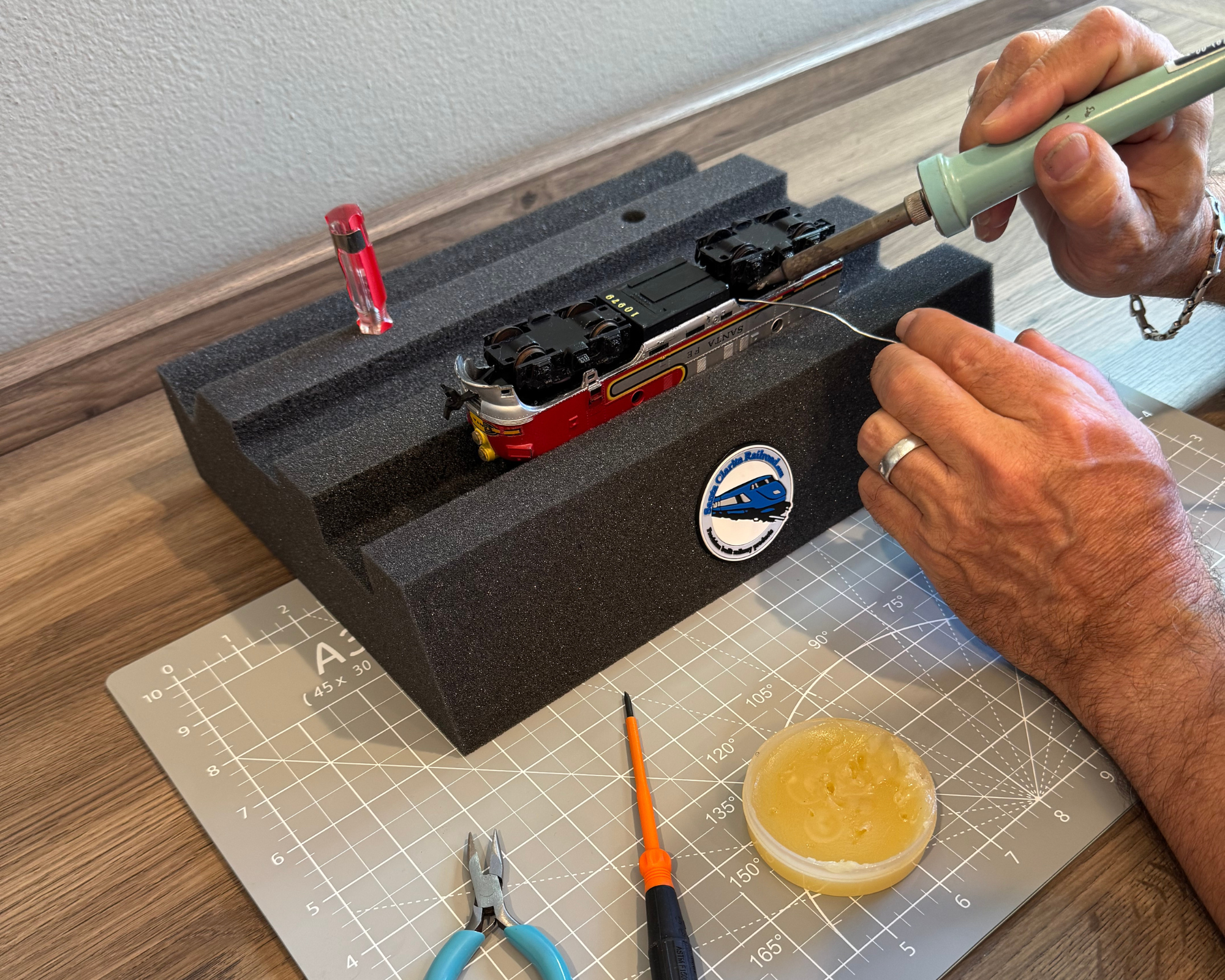 Soldering a locomotive held hands-free in an HO Handy Holder foam cradle