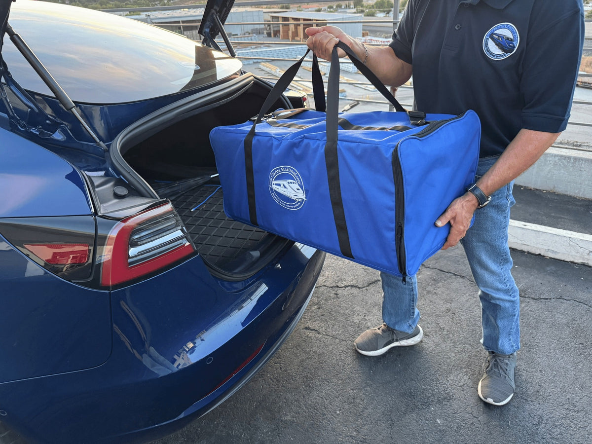 Model railroader lifting a Pro Pak Carrying Case into a car trunk