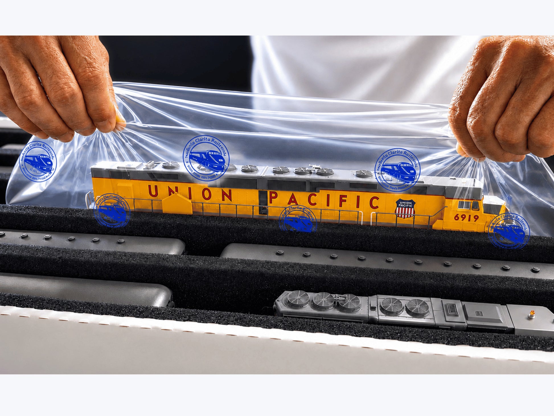 Hands lifting a Union Pacific HO diesel from a Pro Pak box on a Long Easy-Lift Sheet