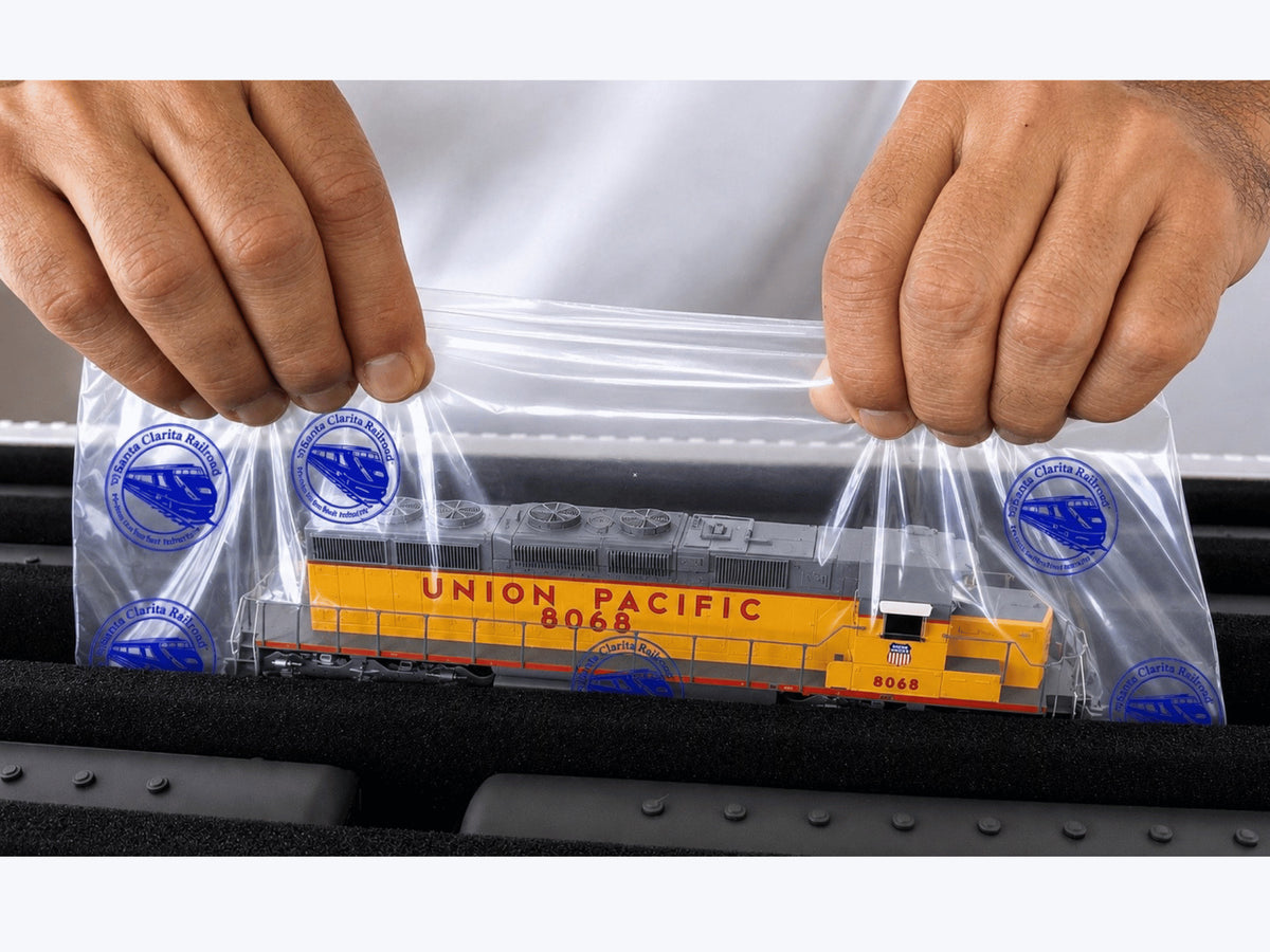 Hands lifting a Union Pacific HO diesel on a Short Pro Pak Easy-Lift Sheet